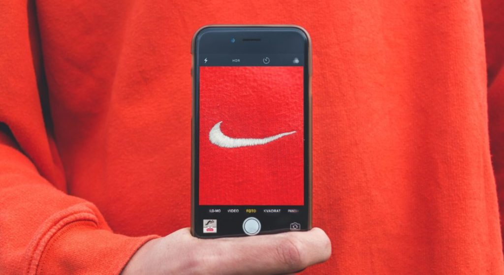 a person holding the phone with an image of nike brand